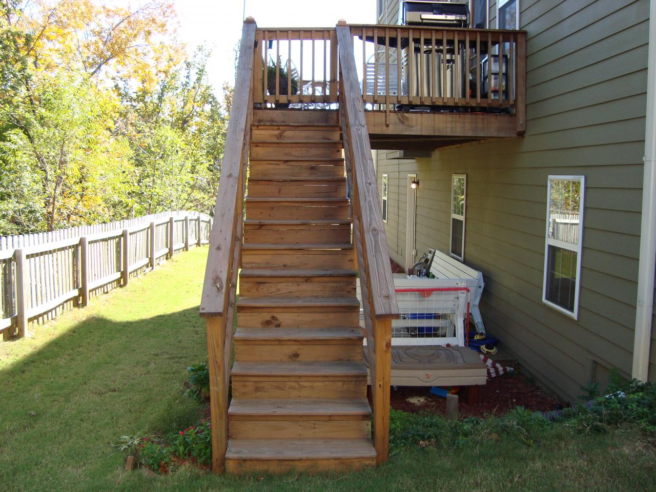Custom-built wooden deck staircase with matching railing and gate