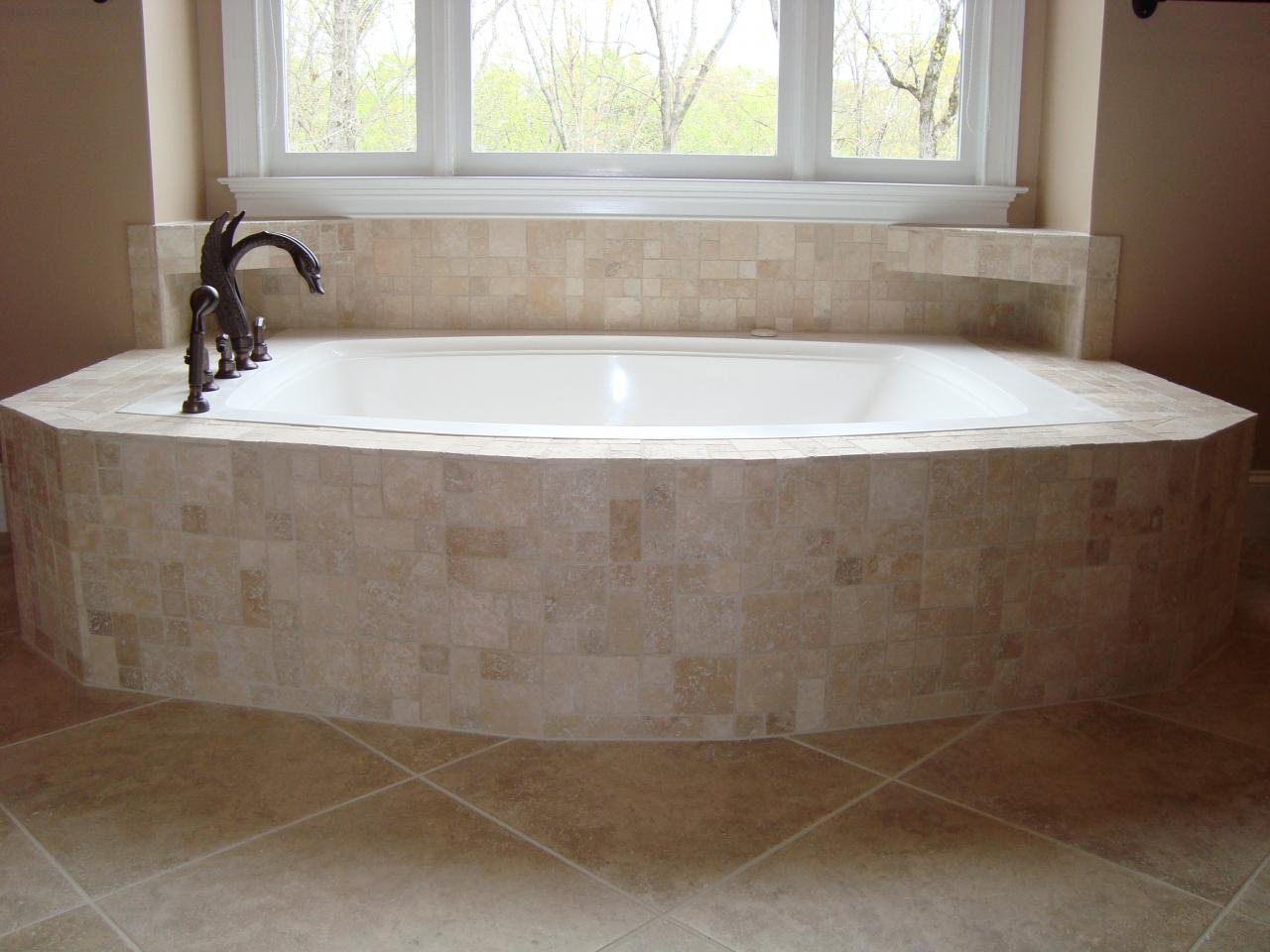 Travertine-tiled tub and shelves
