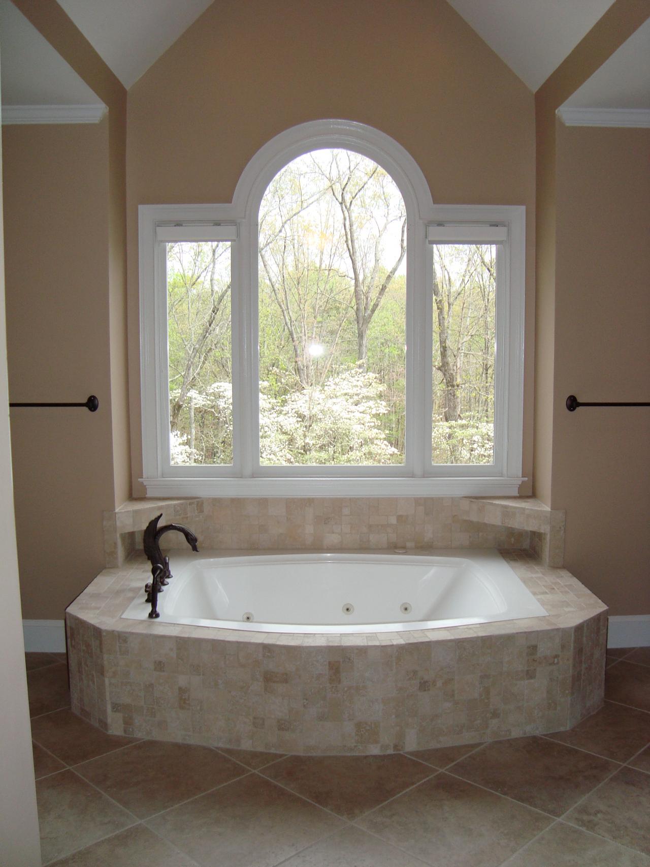 Dimensional jacuzzi tub wrapped in tumbled travertine tile
