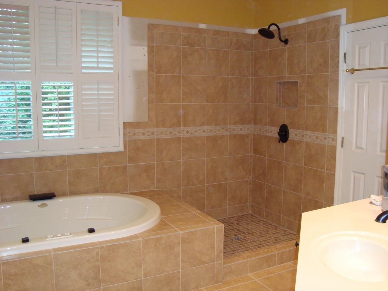 Remodeled Brown master bathroom with tiled tub surround and shower